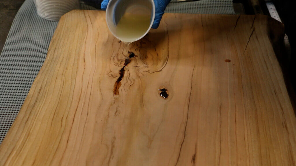 Pouring the epoxy on the live edge coffee table.