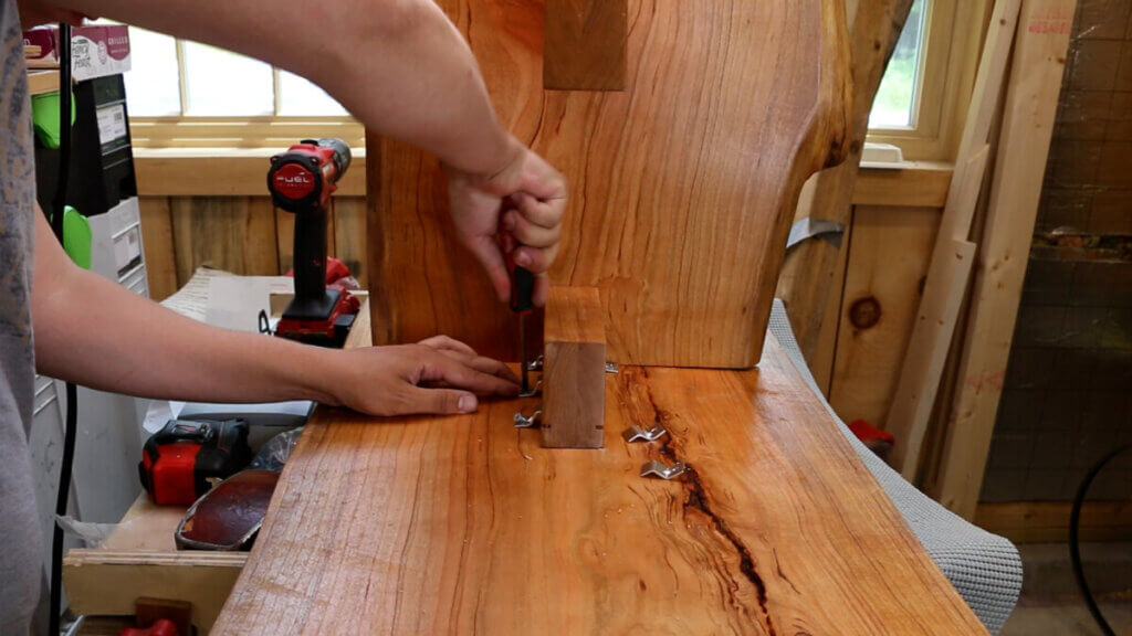 Use a screwdriver to fasten the base to the top of the live edge coffee table.
